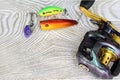 Fishing equipment on a wooden table.fishermans rod reel andÃ¢â¬â¹fishing tackle.Fishing bait, deep black plug withÃ¢â¬â¹ 3-way hookÃ¢â¬â¹